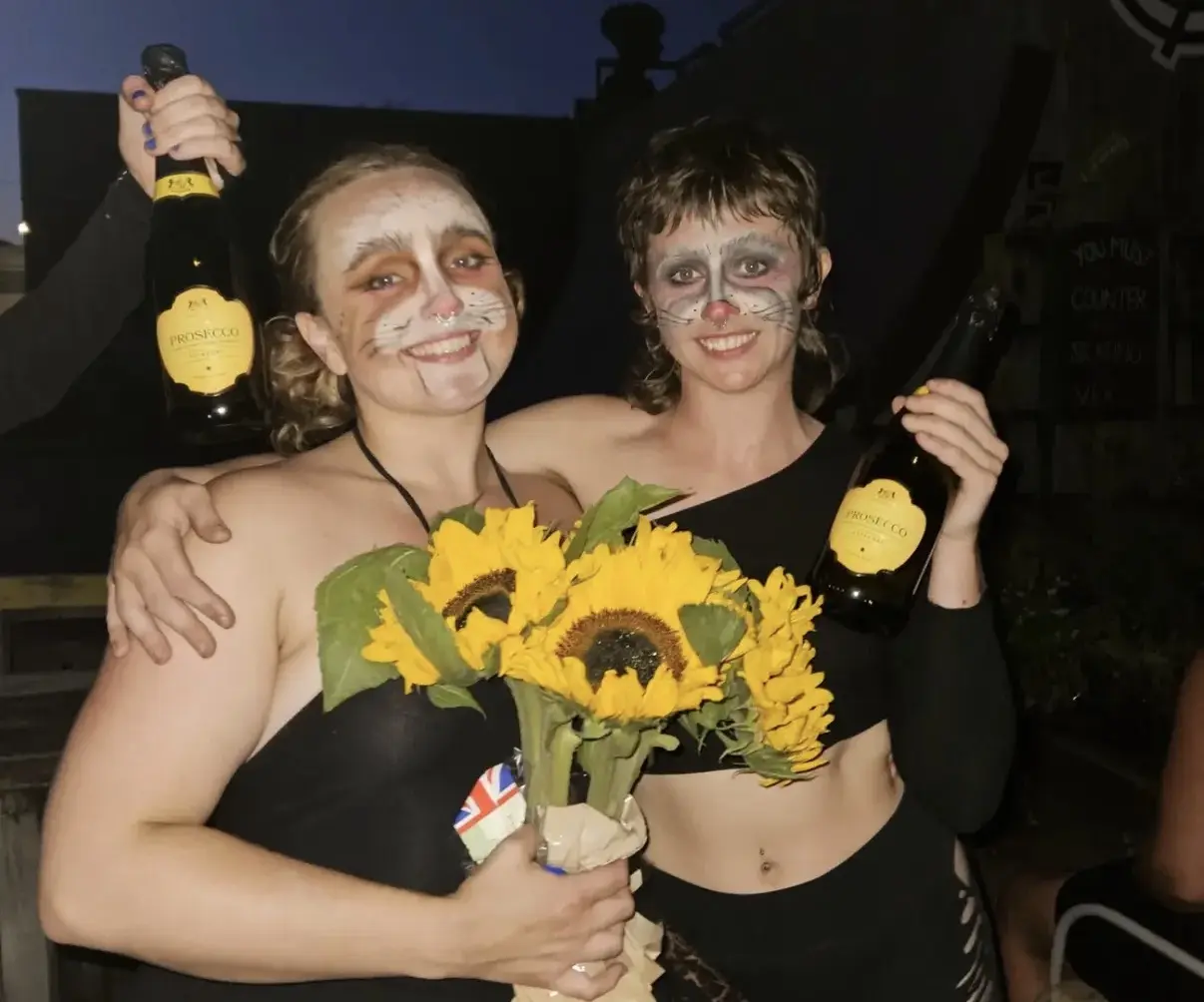 Two costumed performers celebrating after a show