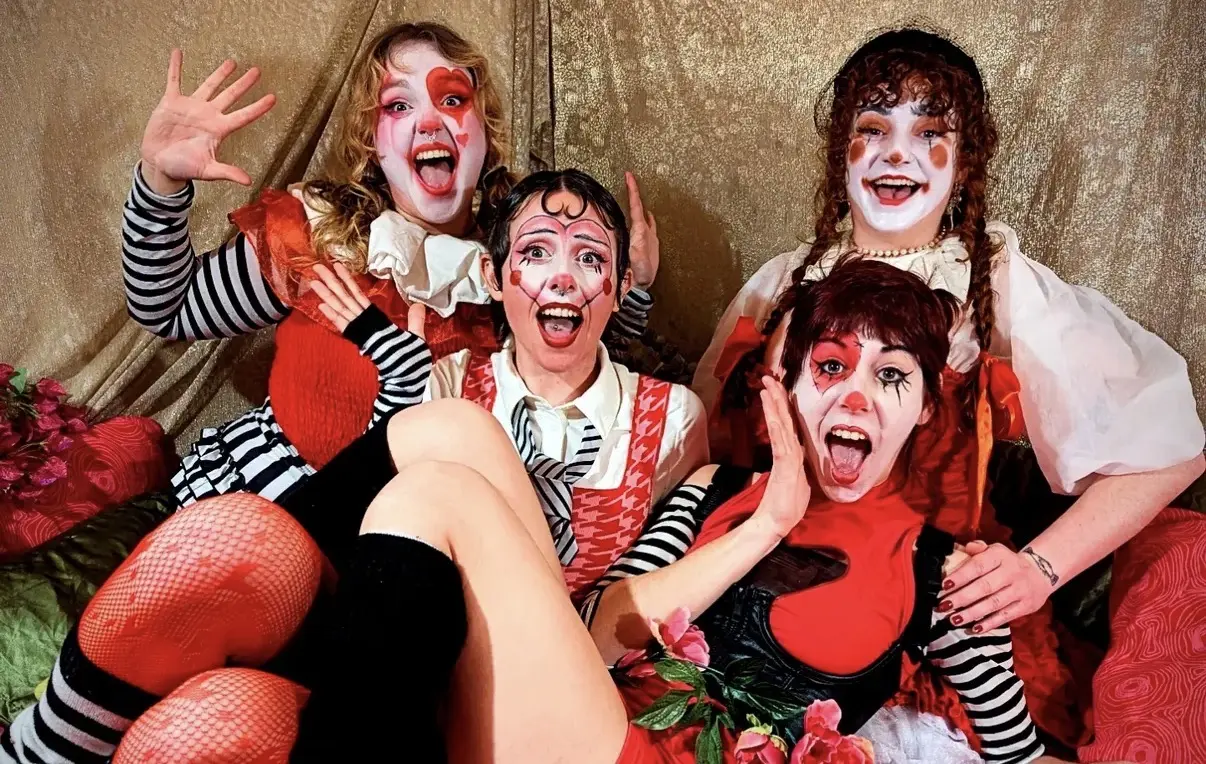 Rhianna and fellow circus performers in theatrical red, white and black costume